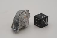 Ein Bruchstück des Meteoriten im Größenvergleich mit einem Meteoriten
